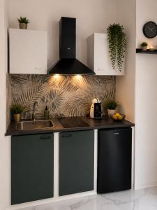 a kitchen with black and white cabinets and a sink at Leonardo Loft in Filettino