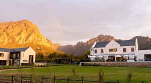 a house with mountains in the background at Kleine Banhoek Manor in Stellenbosch