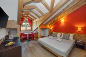 a bedroom with a bed and a red wall at Cavallino Experience - Alpine Wellness Hotel in Rumo +157 photos