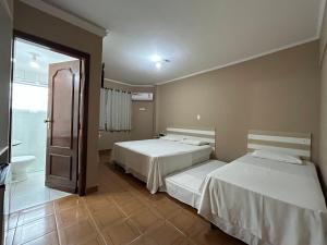 two beds in a hotel room with a bathroom at Ibericas Praia Hotel in Praia Grande +45 photos