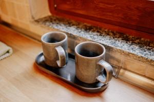 two coffee mugs sitting on a tray on the floor at Casa del Bosco in Rubiana