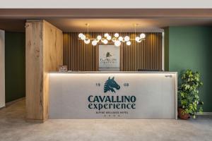a reception desk in a room with a chandelier at Cavallino Experience - Alpine Wellness Hotel in Rumo