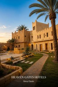 a building with a palm tree in front of it at Heaven Gates Hotel in Siwa