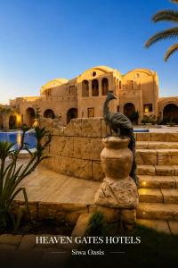 a statue of a bird in front of a building at Heaven Gates Hotel in Siwa