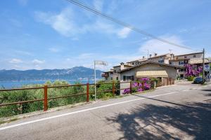 a road with a house and a fence on the side at Casa Antony in Torri del Benaco