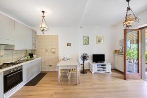 a kitchen with white cabinets and a table and a desk at Casa Antony in Torri del Benaco