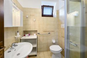 a bathroom with a toilet and a sink and a shower at Casa Antony in Torri del Benaco