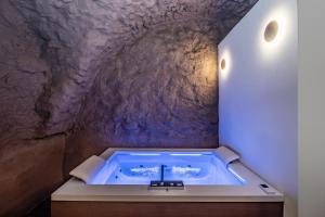 a bath tub in a cave with a stone wall at Cavallino Experience - Alpine Wellness Hotel in Rumo