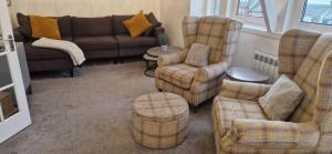 a living room with couches and a couch and chairs at Wee Cumbrae View in Millport