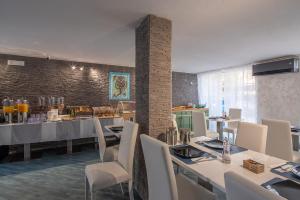 a dining room with white tables and white chairs at Hotel Al Sole in Grado