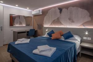a bedroom with a blue bed with towels on it at Hotel Al Sole in Grado