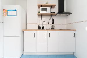a kitchen with white cabinets and a sink at El Rinconcito Cubano en el Centro in Almería