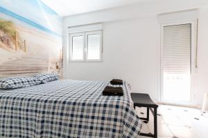 a bedroom with a bed with a checkered blanket at El Rinconcito Cubano en el Centro in Almería