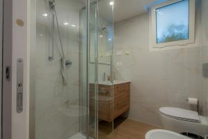 a bathroom with a shower with a toilet and a sink at Hotel Al Sole in Grado