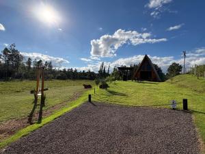 a field with a barn and a dirt road at Sítio das Amoreiras- Cabana in Tabapira