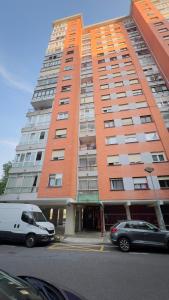 a tall building with cars parked in front of it at Familiar y Agradable in San Sebastián