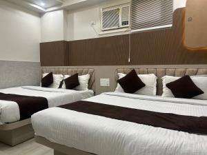 a bedroom with two beds and a window at Grand Tree Hotel Shree Guru in New Delhi