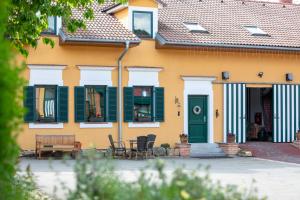 a yellow house with green shutters and a table and chairs at Villa Gineta in Štěchovice