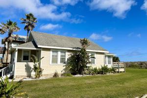 a house with palm trees in a yard at Sun & Fun Oceanfront Saint Augustine Beach! in St. Augustine