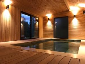 an empty swimming pool with a tv in a wooden house at Gite Des Sibourgs - Piscine & Clim in Bourdeaux