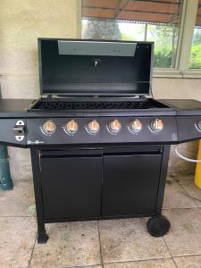 a black stove top oven sitting on a patio at Gite Des Sibourgs - Piscine & Clim in Bourdeaux