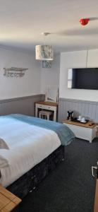 a hotel room with a bed and a tv at Moon Tap Hideaway in Bridlington