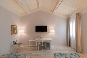 a living room with a desk and a tv on the wall at Villa Mirandola in Mirandola