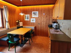 a kitchen with a wooden table and some chairs at Ciasa Lovara in Lovara