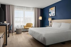 a hotel room with a bed and a chair at City Express By Marriott Gettysburg in Gettysburg +31 photos