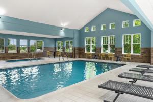a swimming pool with tables and chairs in a building at City Express By Marriott Gettysburg in Gettysburg
