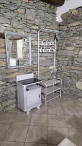 a stone bathroom with a chair and a mirror at Residenza Villa Paradiso in Villadossola