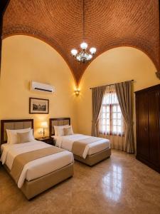 two beds in a large room with a large window at Luxor Mountain View in Luxor +2 photos