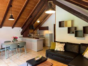 a living room with a couch and a table and a kitchen at la Mansarda dello Zio in Ceppo Morelli