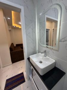 a white bathroom with a sink and a mirror at جراند فاندا سويتس الغردقه Grand Vanda Suites Hurghada in Hurghada +124 photos