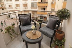 a balcony with two chairs and a table on a balcony at جراند فاندا سويتس الغردقه Grand Vanda Suites Hurghada in Hurghada