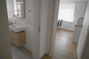 a white bathroom with a sink and a mirror at Ferienwohnung Talblick Wilthen in Wilthen +25 photos