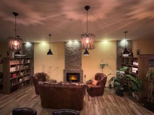 a living room with leather chairs and a fireplace at Garden House in Apatin