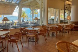 a restaurant with tables and chairs and a view of the ocean at Marriott Isla Verde Beach Resort in Carolina