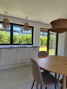 a kitchen with a table and chairs and windows at Kysthusene in Gilleleje