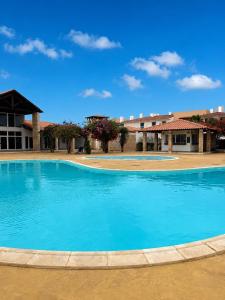 a large blue swimming pool in front of a building at Aurora D Sal, Beach House in Santa Maria