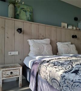 a bedroom with a bed and a side table at Erve 't Hacht in Ane