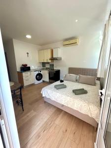 a bedroom with a large bed and a kitchen at Marica & Kata in Vrgorac