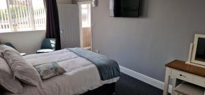 a bedroom with a bed with a television on the wall at Moon Tap Hideaway in Bridlington