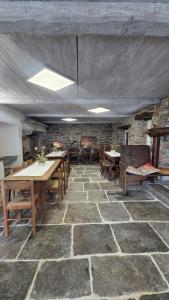 a room with tables and chairs and a stone floor at Residenza Villa Paradiso in Villadossola