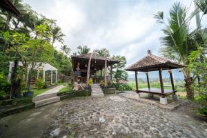 a house with two gazebos in a forest at Medukuh Point Hill in Karangasem