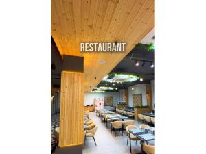 a restaurant with tables and chairs and a sign that reads restaurant at Hotel Arena in Nasīrābād