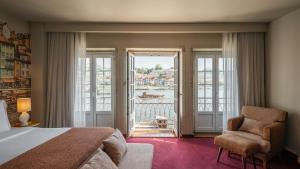 a bedroom with a bed and a chair and a balcony at Pestana Vintage Porto Hotel & World Heritage Site in Porto