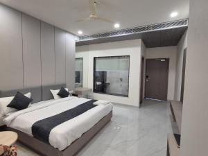 a bedroom with a large bed and a large window at Hotel Arena in Nasīrābād