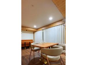 a dining room with a wooden table and chairs at Hotel Arena in Nasīrābād