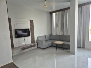 a living room with a couch and a tv at Hotel Arena in Nasīrābād +25 photos